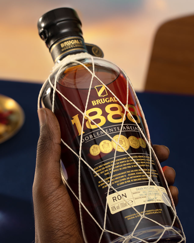 Brugal Flasche von einer Hand gehalten