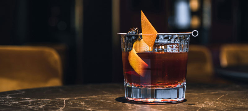 Maker´s Mark Cherry Old Fashioned Cocktail im Glas mit Orangenscheibe auf einem Tisch