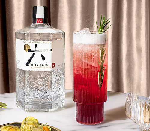 Roku Gin Flasche mit dem Cocktail Roku Winter Spritz in einem Glas auf einem Tisch