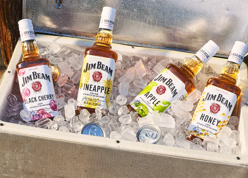 Jim Beam Pinapple mit den anderen Sorten Apple, Honey und Black Cherry in einer Kühlbox voller crushed Eis