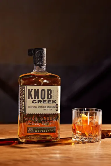 A bottle and a glass of Knob Creek bourbon whiskey