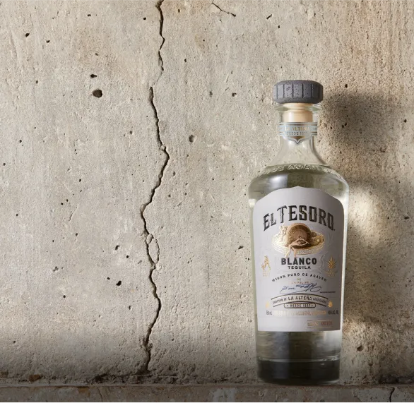image of El Tesoro Tequila bottle placed beside a wall