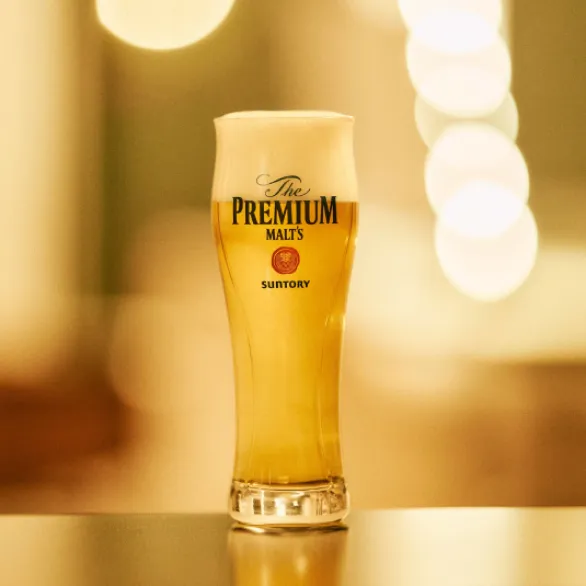 Full glass of Suntory beer on a table