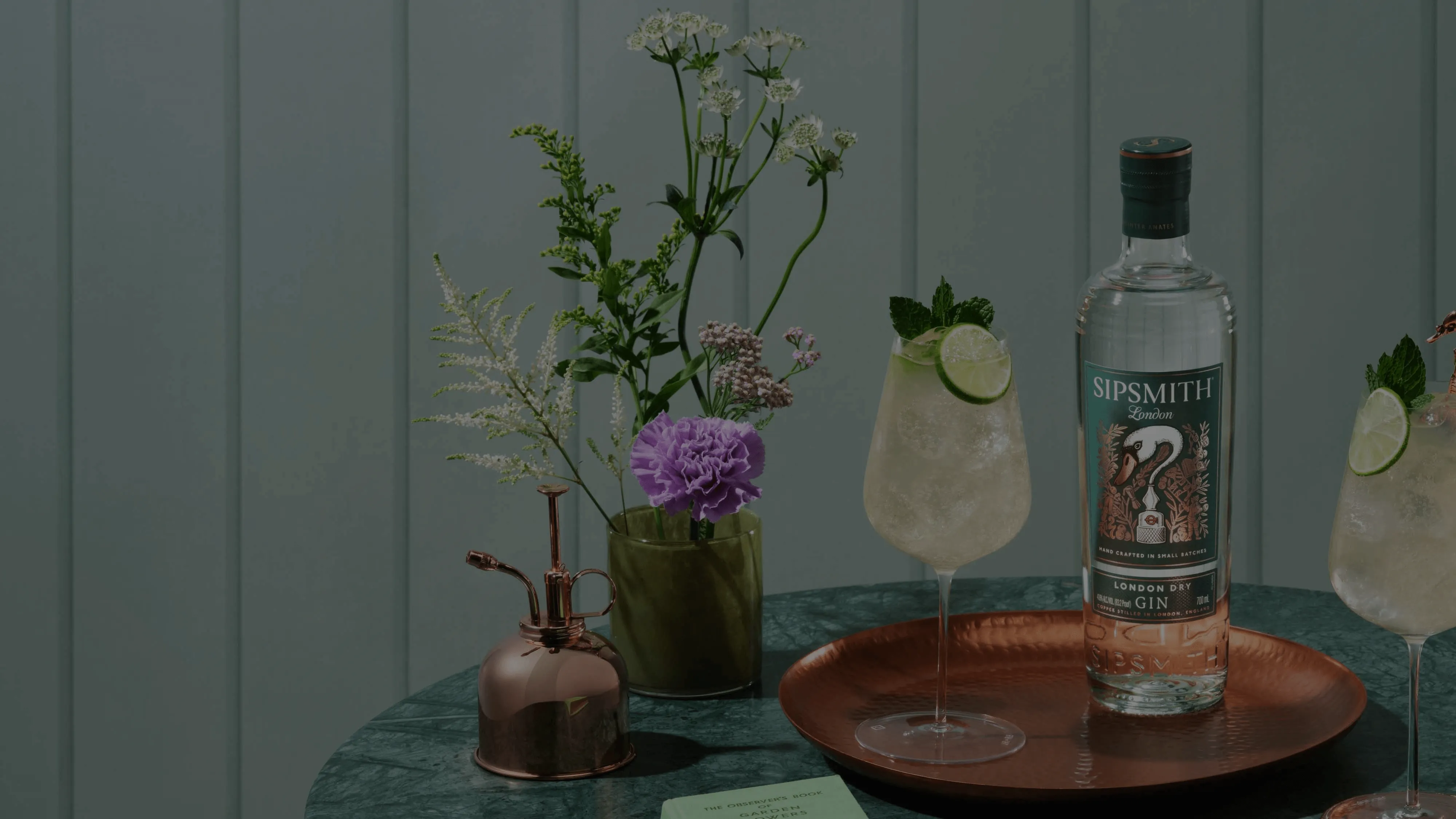 A bottle of Sipsmith gin next to a couple of glasses of gin-based cocktails