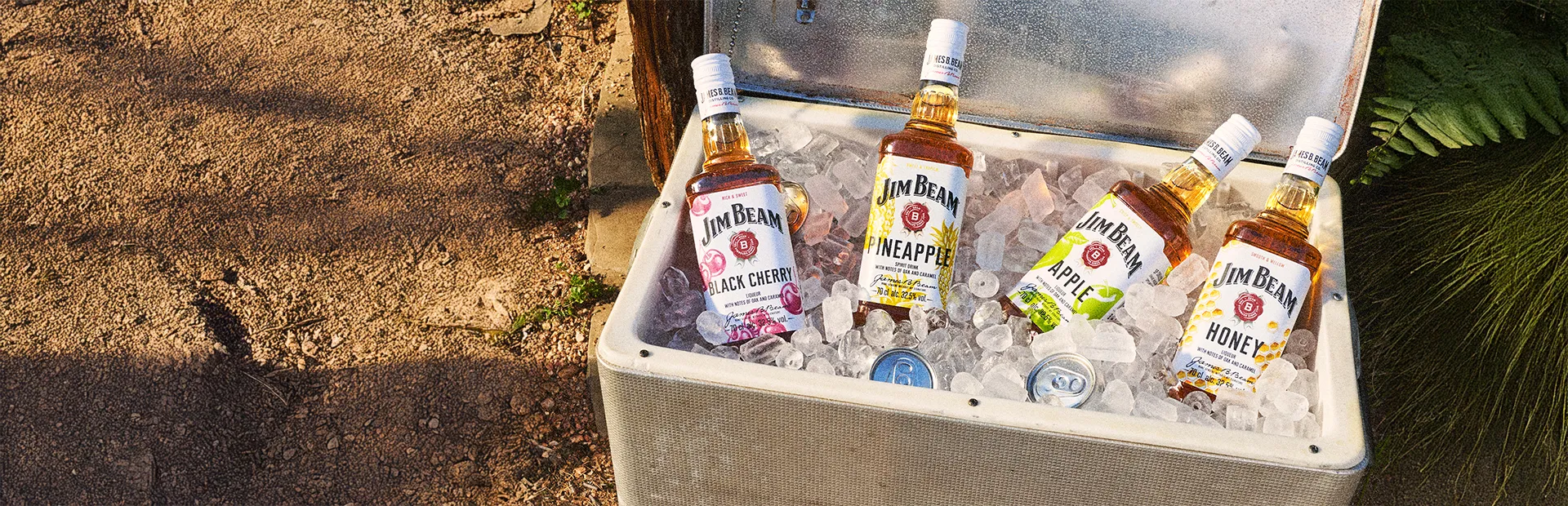 Jim Beam Pinapple mit den anderen Sorten Apple, Honey und Black Cherry in einer Kühlbox voller crushed Eis
